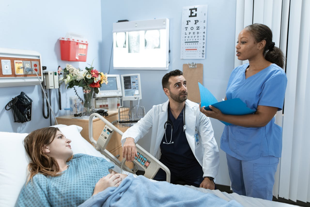 Doctors and nurse discussing patient's treatment in a hospital room.